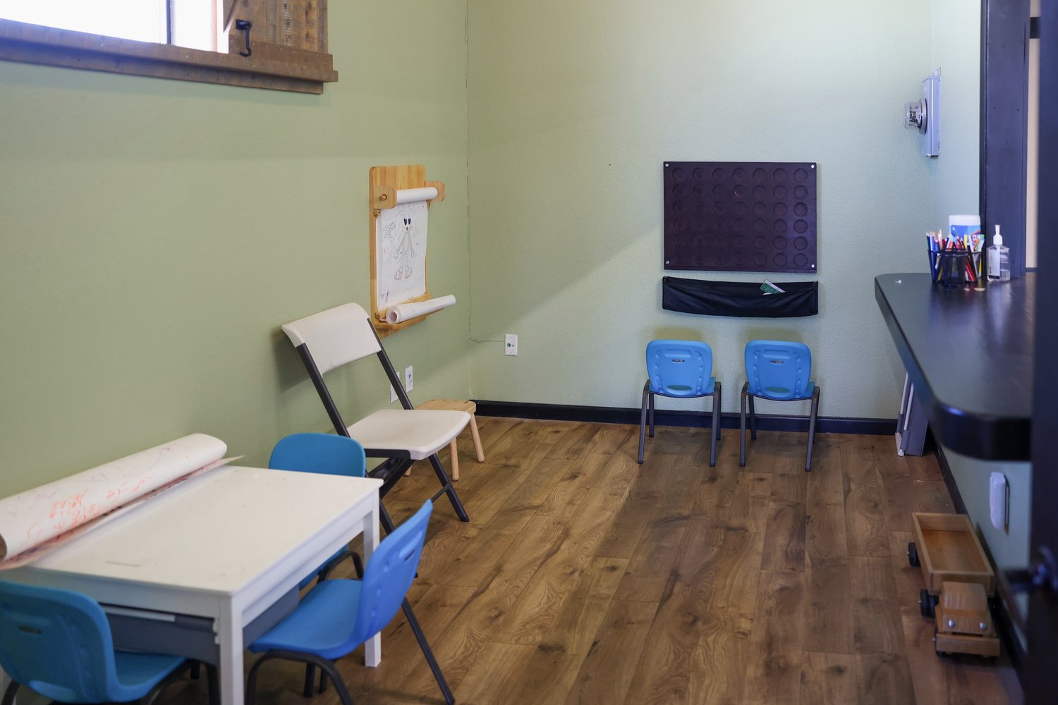 Kids' area with an art easel, table, and chairs